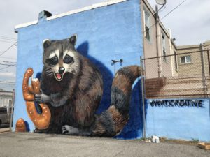 mural of raccoon holding a Wawa pretzel